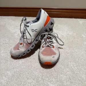 On Running White and Orange Athletic Shoes